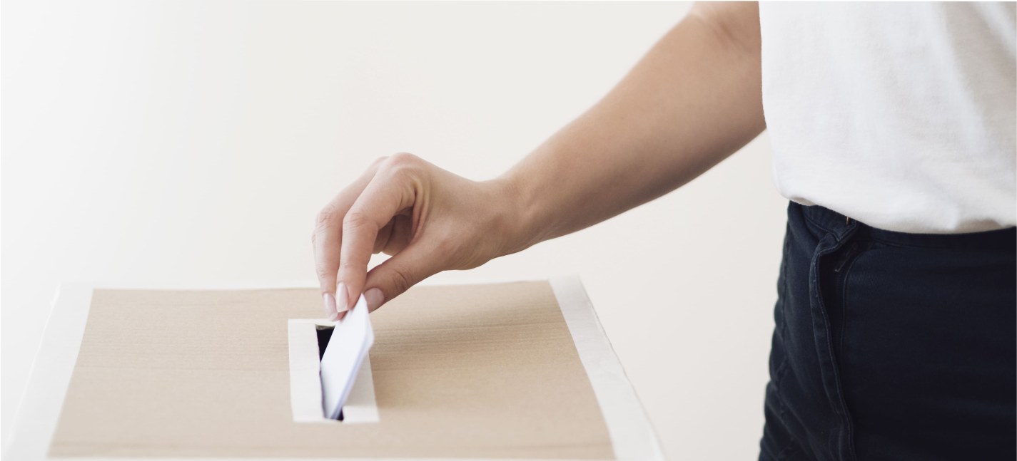 side view person placing ballot in election box 1